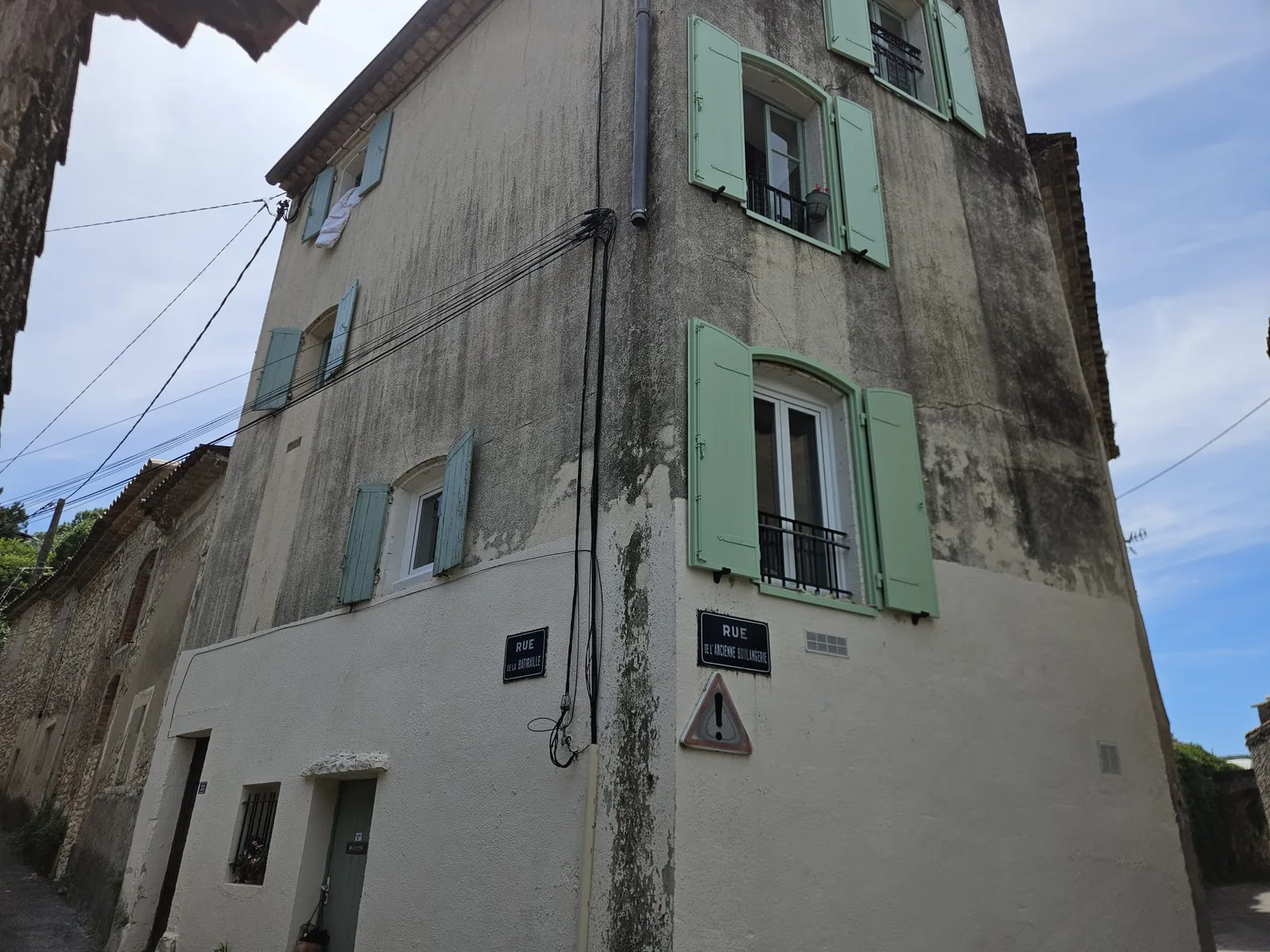 Vue intérieure d'une fenêtre PVC blanche moderne avec double vitrage et vue sur toits et arbres à Dions.
